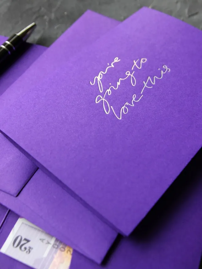 Hand foiled cash card or money wallet in a royal purple colour handfoiled in shiny holographic foil text which says ‘you’re going to love this’.