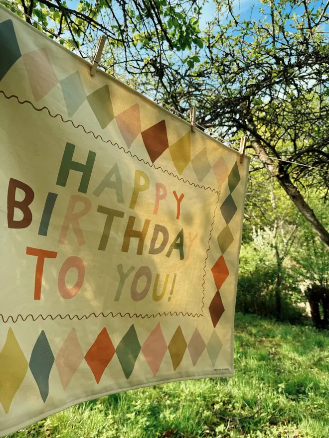 Heirloom Fabric Birthday Banner, hanging in a tree. 