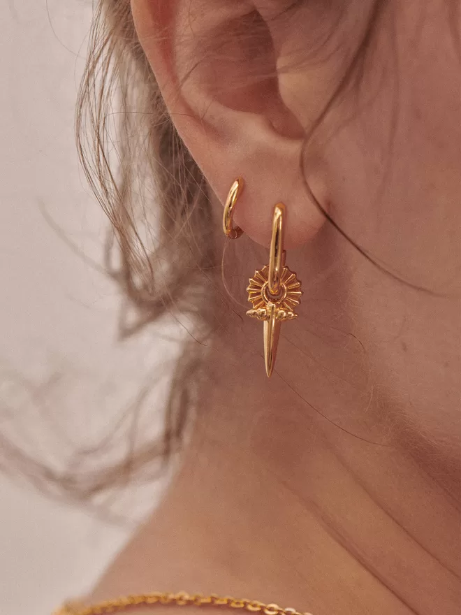 woman wearing gold earrings with charms