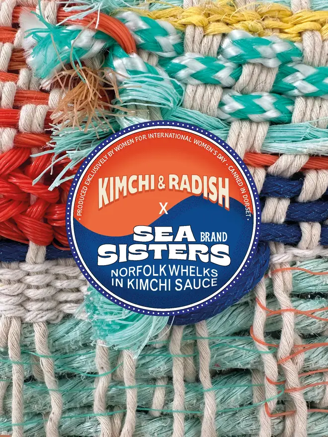 A closed tin of Sea Sisters Norfolk Whelks In Kimchi Sauce on a background of fishing nets