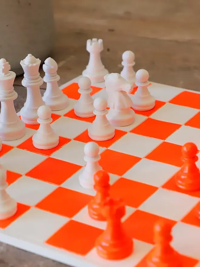 Handmade Jesmonite Chess Board, a handmade colourful chess board sitting on a wooden surface. 