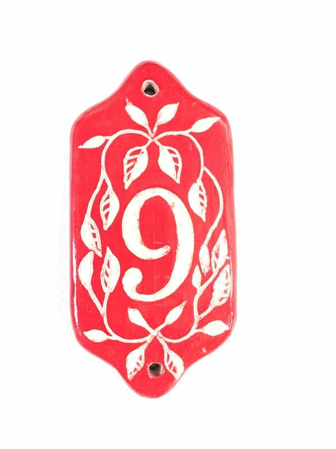 Red Sgraffito Leaf Address Tile. A tile with ‘9’.