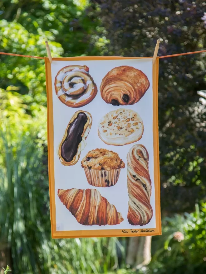 Pastry Themed Tea Towel seen hanging on a washing line.