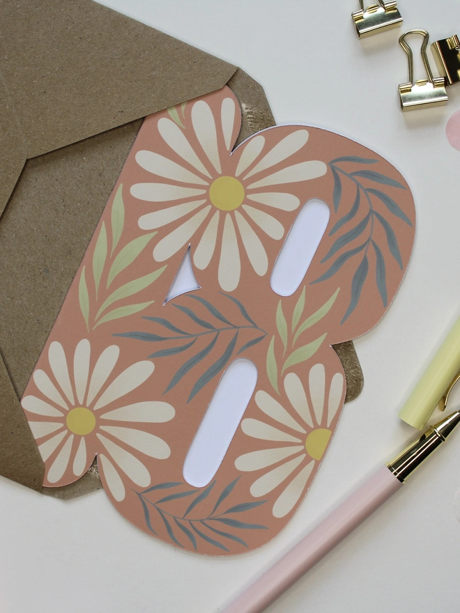 floral 18th birthday card. card shaped like number 18 with daisies and leaves.