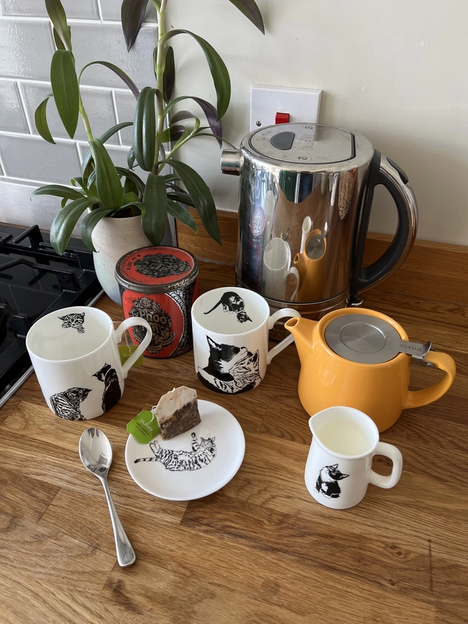 Pussy cat range being used in the kitchen for cups of tea with a milk jug and a trinket tray for used tea bags