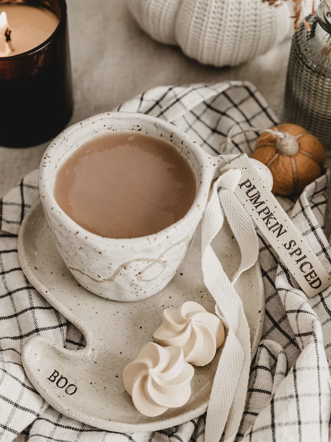 ceramic mug with a 'pumpkin spiced' ceramic tag tied to the handle