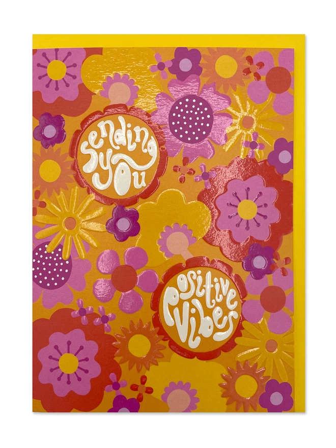 Thinking of You card with ’Sending you positive vibes’ message in chunky 70’s inspired hand lettering on a psychedelic floral pattern of yellows and oranges, complimented with pops of pink and purple