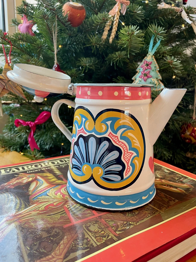 White enamel coffee pot hand painted with a fairground design in blue, pink and yellow