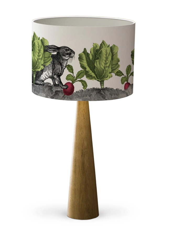 Peter Rabbit inspired Drum Lampshade featuring a Rabbit among lettuces and radishes on a wooden base on a white background