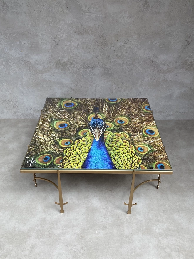 gold peacock image on metal frame coffee table