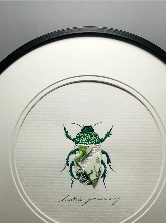 Hand-drawn, painted, mosaic clay, vintage Chinese Green Dragon pottery insect on white double mounted card, in a black circular frame.
