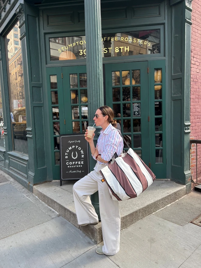 Brown stripe bag on woman outside coffee shop