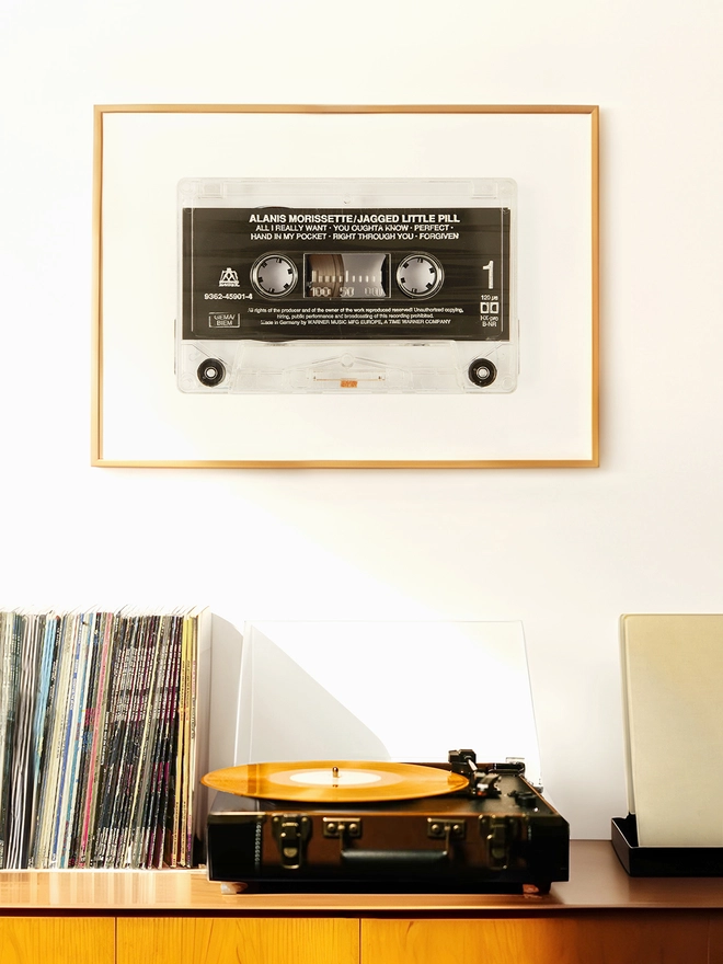 jagged little pill alanis morrisette cassette tape print. print in wooden frame on wall above record player and vinyl collection.