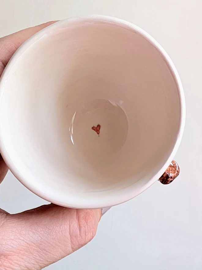 white espresso cup with tiny robin red breast bird and tiny red heart inside the mug