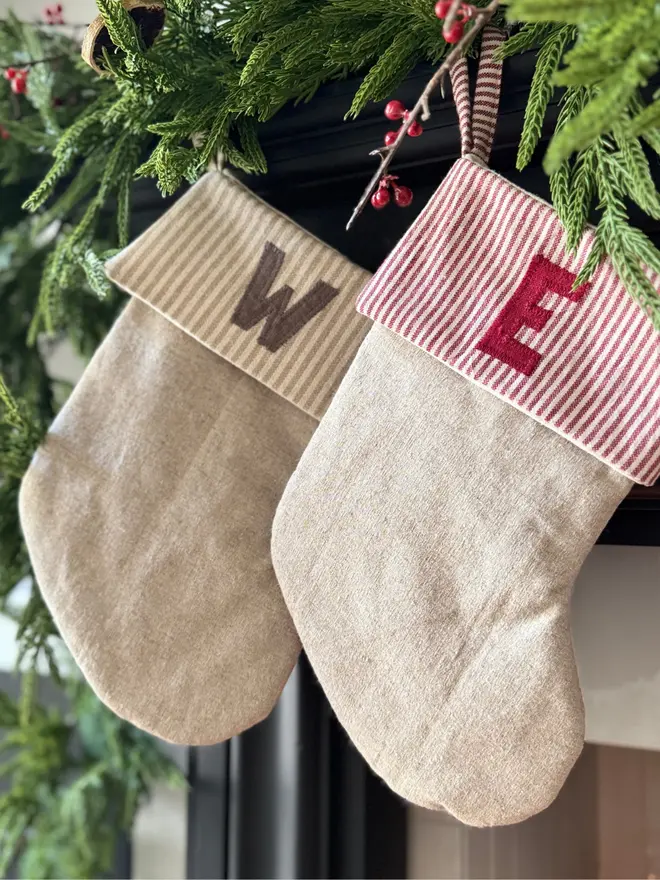 Striped Mini Christmas Stocking. Two stockings hanging from a mantle with red stripes and initials W, E