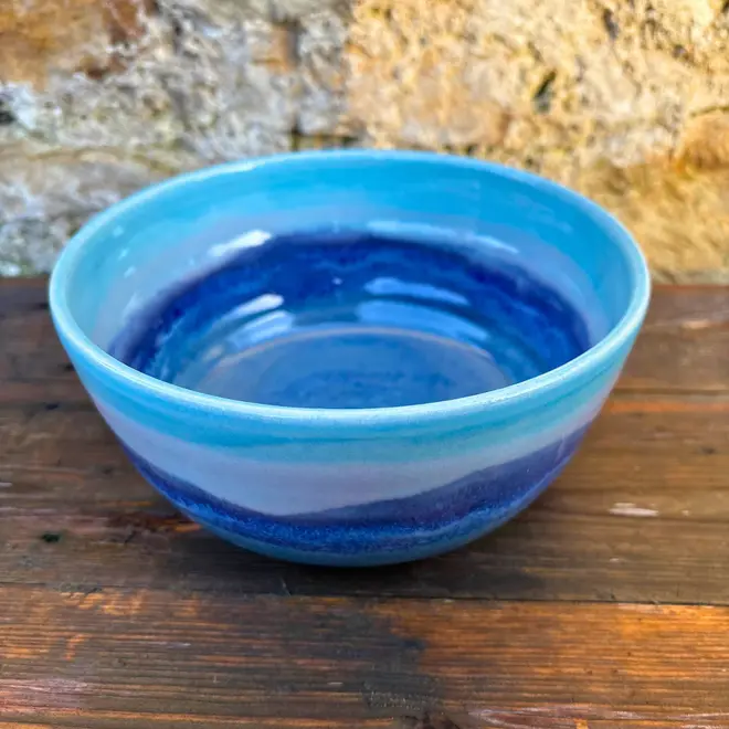 Landscape Ramen Bowl, a colourful ramen bowl placed on a wooden surface in front of a brick backdrop. 
