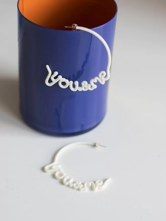 You & Me hoops by Zoe Sherwood in white seen in a blue cup.