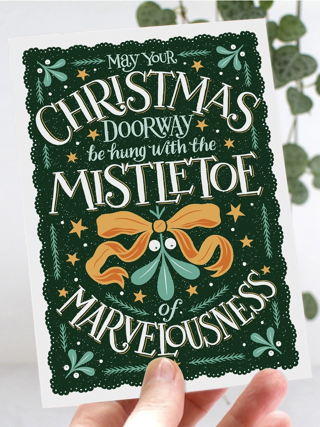 Christmas mistletoe card in hands