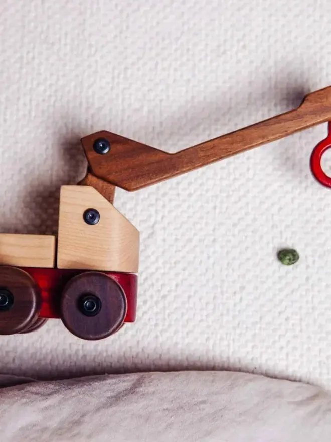 Walnut & Padauk Crane Wood Heirloom Toy, on a white table. 
