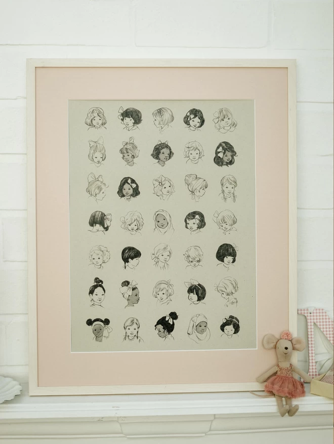 A3 art print of vintage girls wearing differnt styles of hairbows shown on a mantle piece in a white frame with pink mount