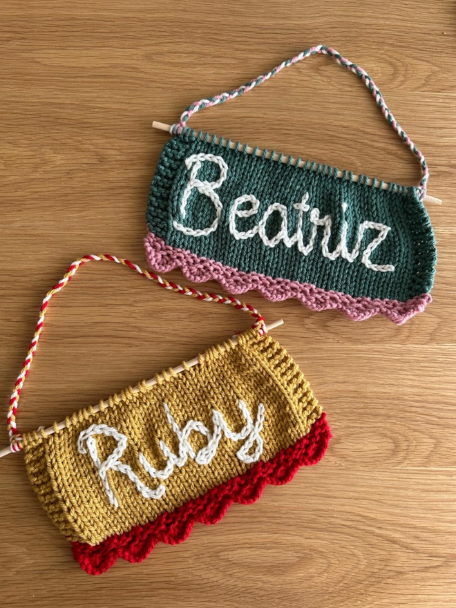 The Scallop Banner. A selection of scallop banners in reds, pinks, greens and yellows, with white lettering.