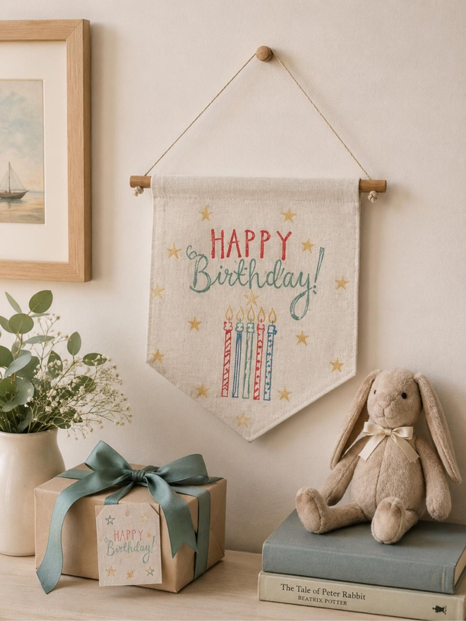 reusable birthday cotton wall hanging. a hanging wall banner with a happy birthday message and printed birthday candles.
