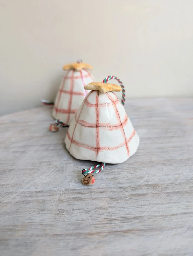 white and red check hanging christmas bell decoration with a tiny robin