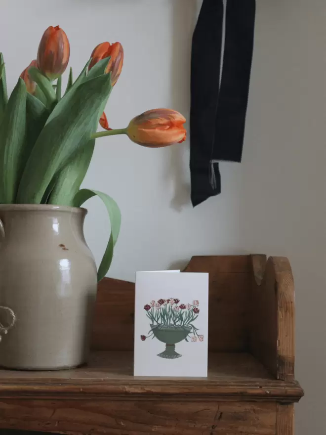 Mini floral card next to vase of tulips