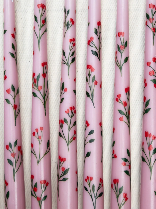 Pink taper candles hand painted with wildflower blossoms. 
