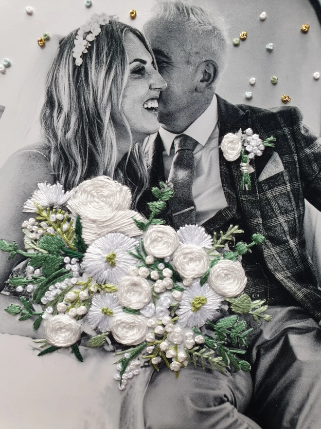 Close up image of wedding photo in B&W with hand embroidered bouquet & confetti