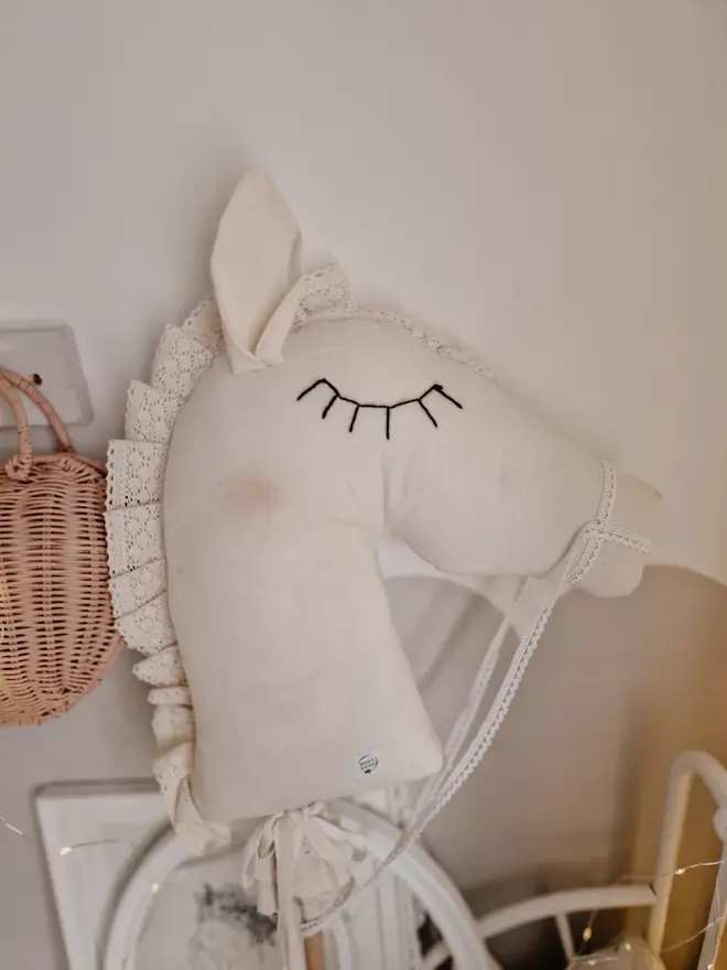 Handmade Cotton Hobby Horse Nursery Decoration, a cotton hobby horse sitting in a child's bedroom surrounded by other bedroom accessories. 