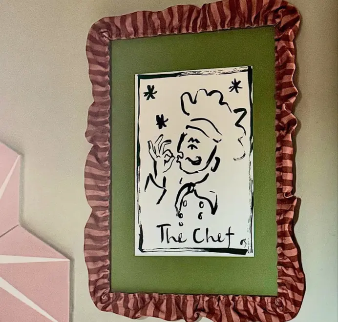 picture frame with red striped ruffled border framing green mount and picture