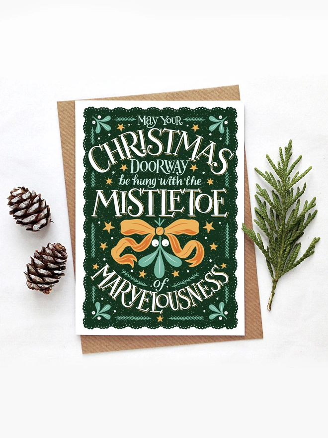 christmas mistletoe card with fir cones and leaves