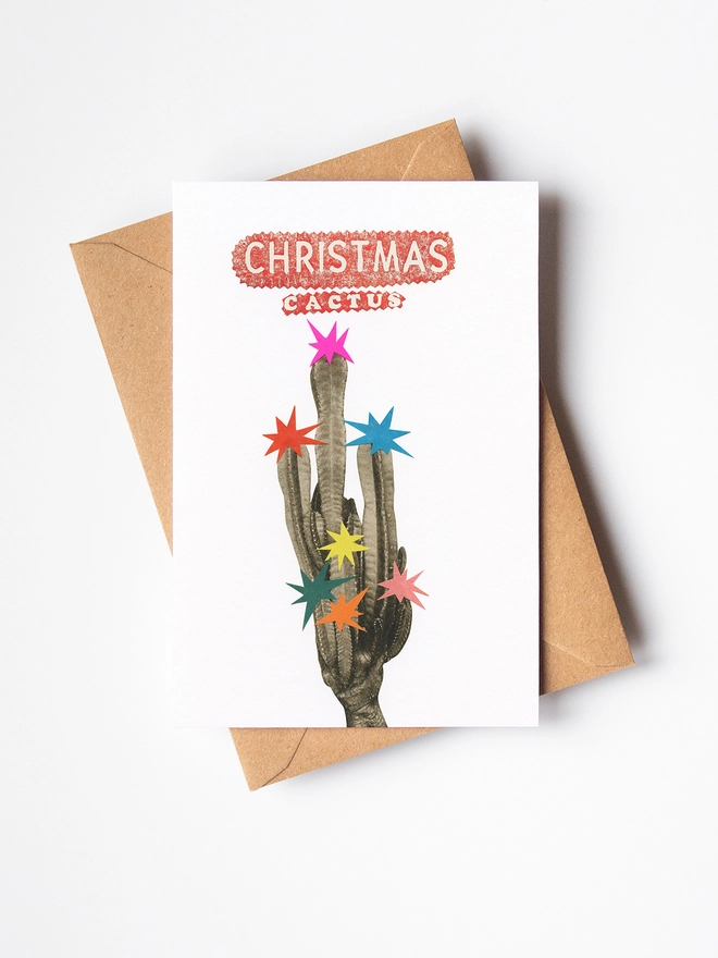 A vibrant, retro Christmas card featuring a tall cactus decorated with colourful stars.