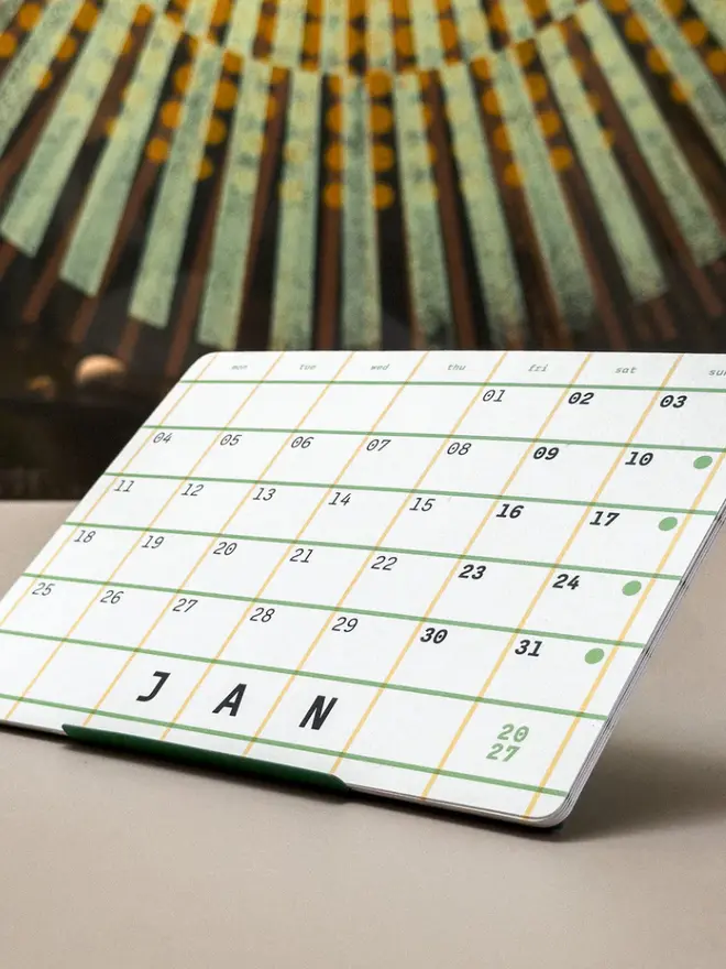 Squared: green 2027 Monthly Desk Calendar, on a table. 