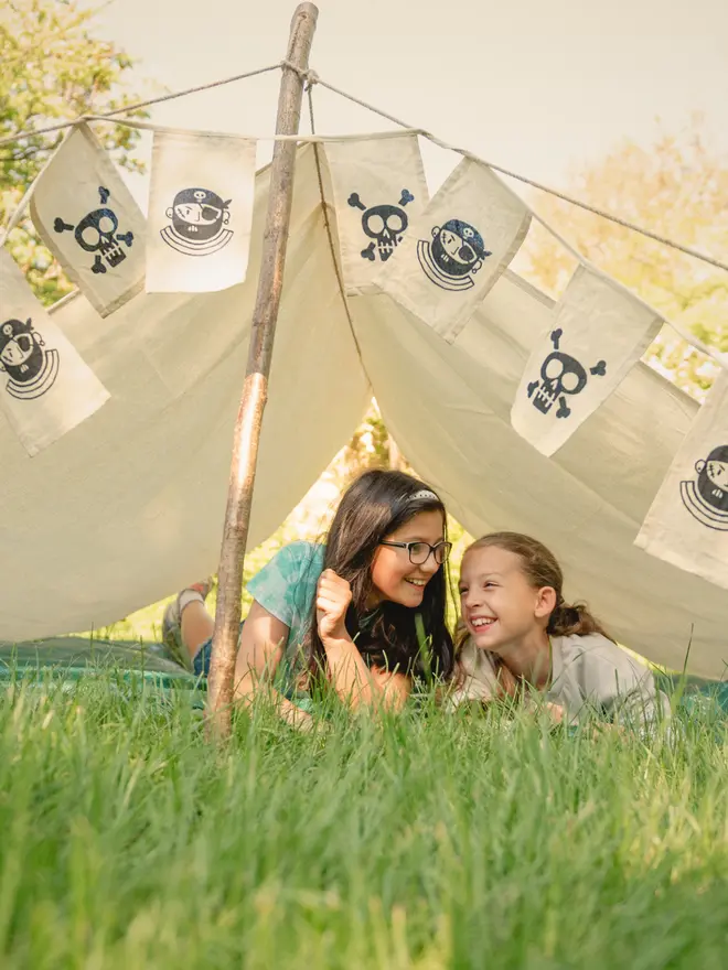 Children in a pirate den held up by wooden den poles