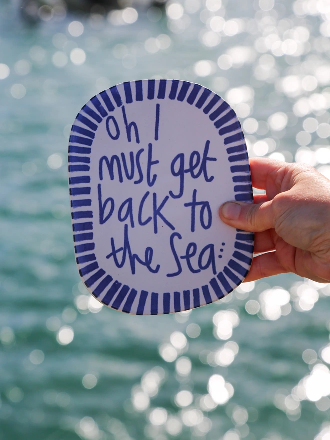 wall plaque in front of a glittering sea