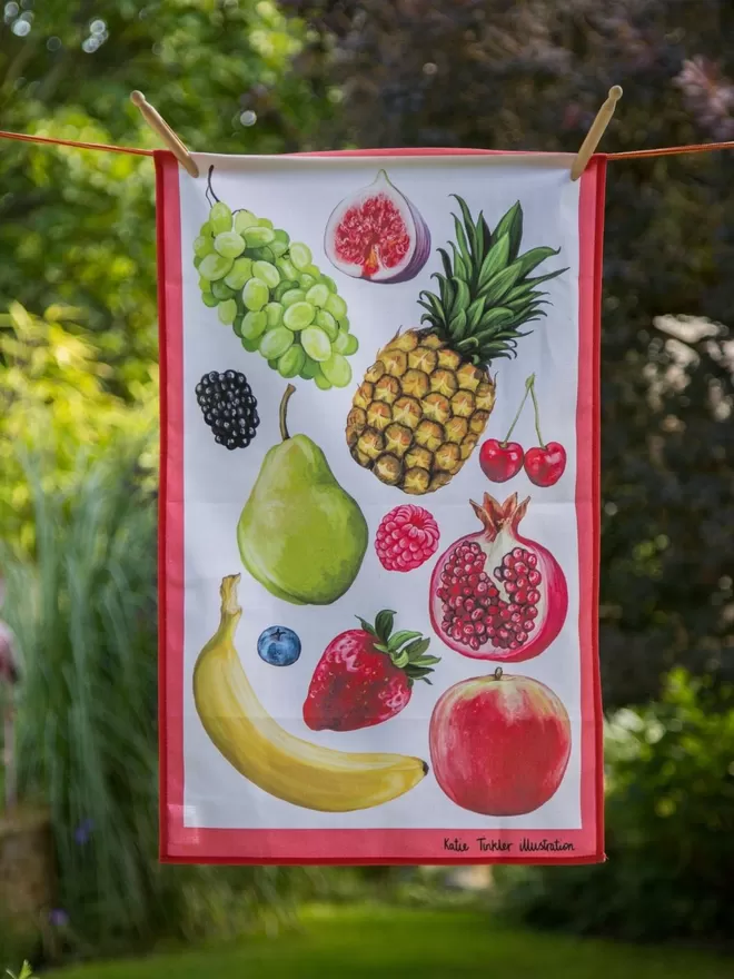 Fruit Themed Tea Towel seen hanging on a washing line outside.