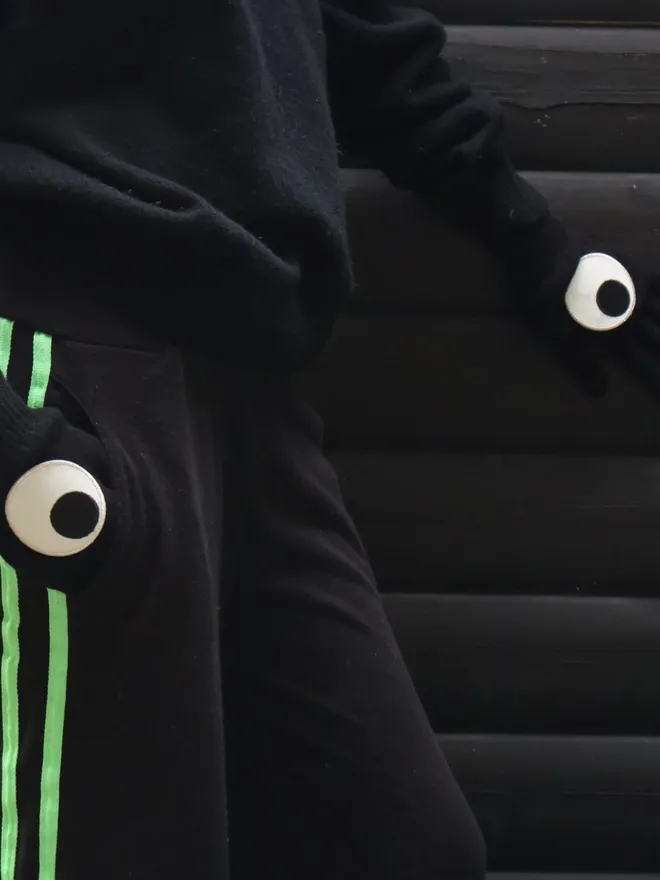 Googly eye iron on patches on black gloves inside tracksuit pockets