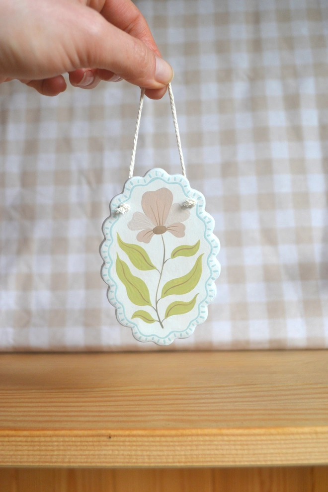 hanging ceramic ornament with blue border and pink an green flower