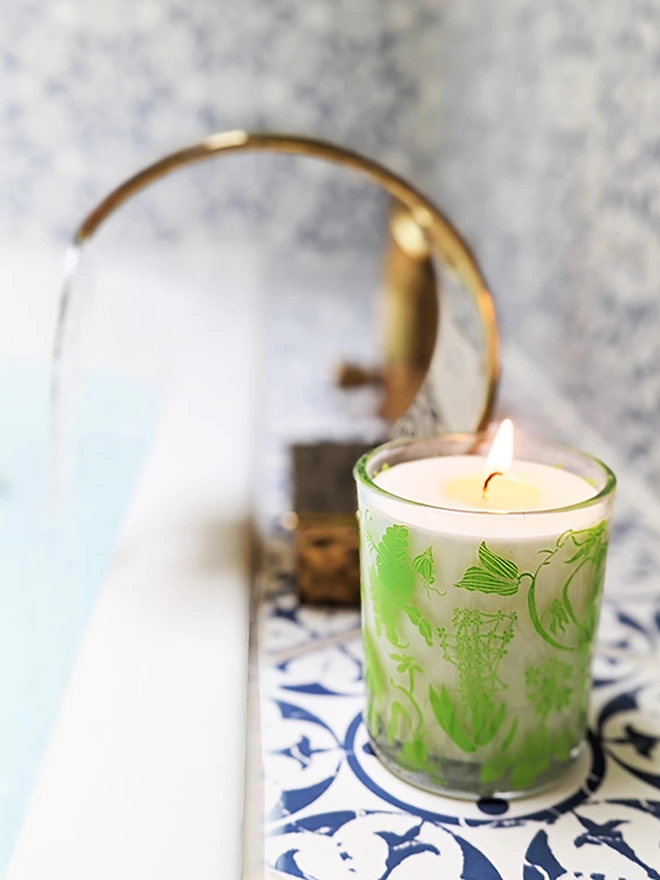 laura's floral, wild fig & grape charity candle in a reusable glass in a bathroom setting
