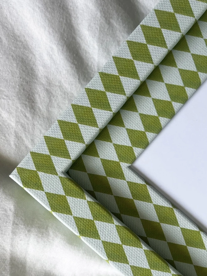 Chartreuse & Frost Harlequin Frame, a colourful patterned frame sitting on a plain white surface. 