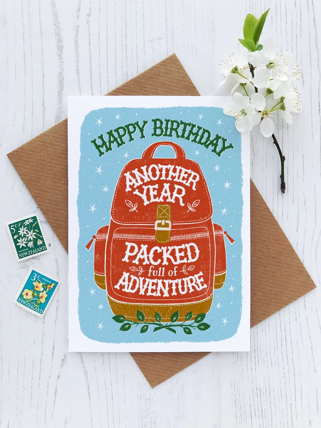 adventure birthday card with red backpack and blue background