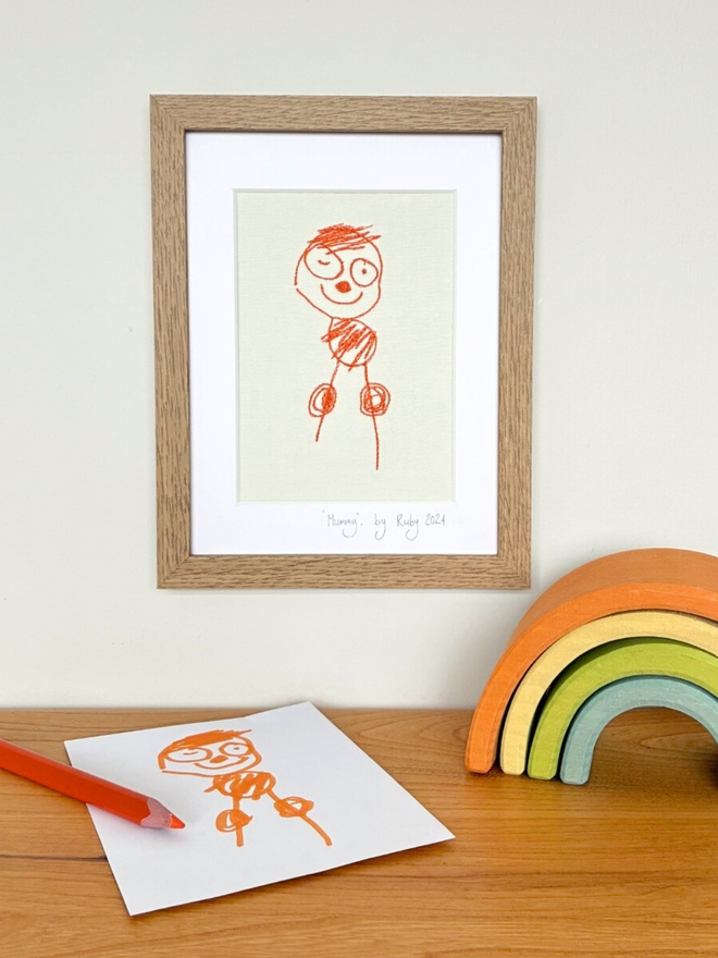 Bespoke embroidered children's illustration showing an orange child's drawing