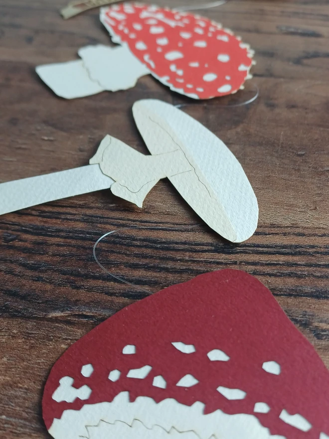 Closeup of Paper Decorations: Bright Red and White Toadstool, Dark Red and White Toadstool, Cream and White Mushroom