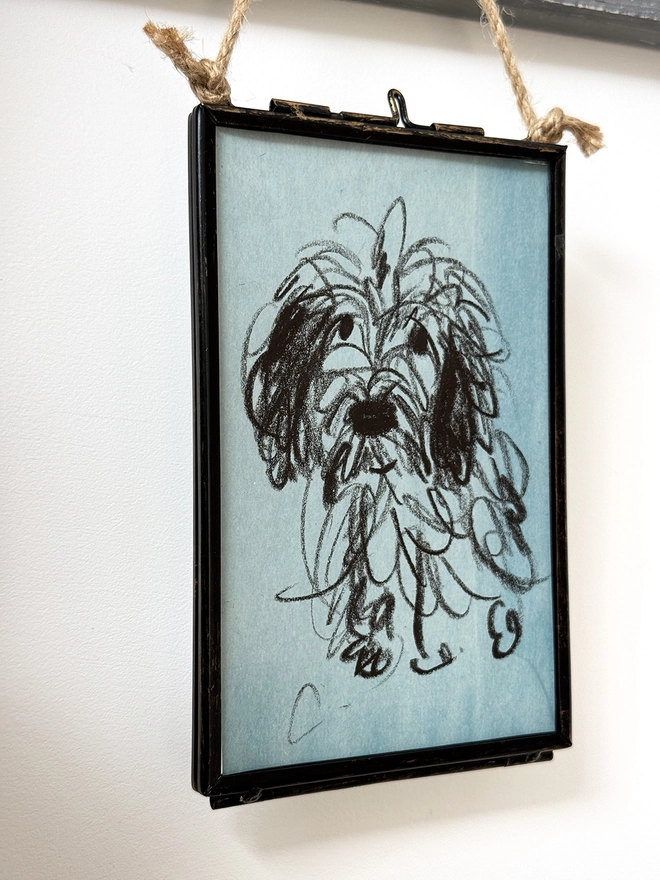 sketchy portrait of dog on blue paper in metal frame