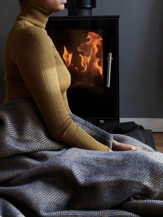 Organic Wool Throw, a person with the wool throw draped over them. 