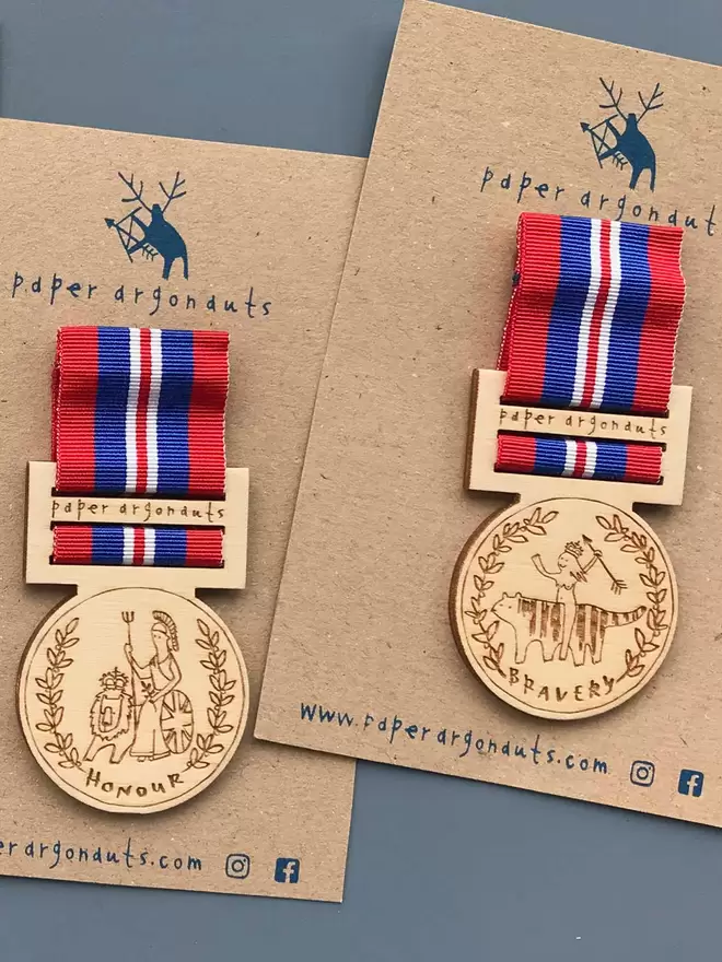 Two wooden medal pin badges are shown, engraved with 'Honour' and 'Bravery', on blue and red ribbon