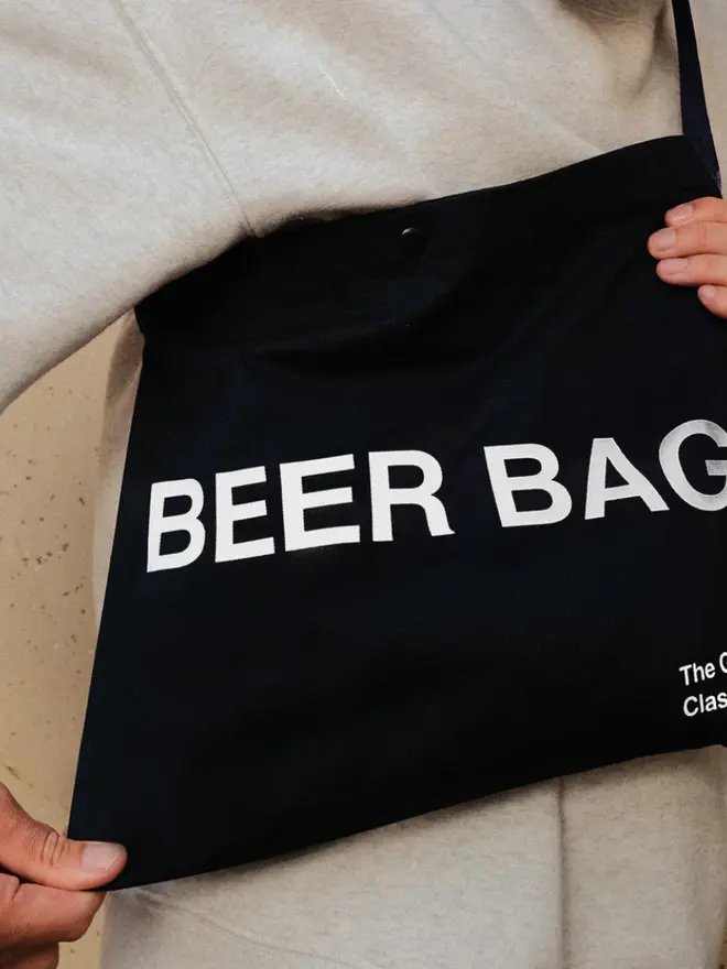 'Beer Bag' Musette Bag, against a grey background. 