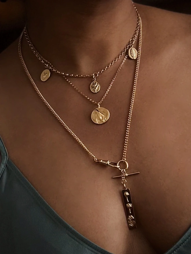 Gold plated luck watch chain as part of a neckmess worn by a model